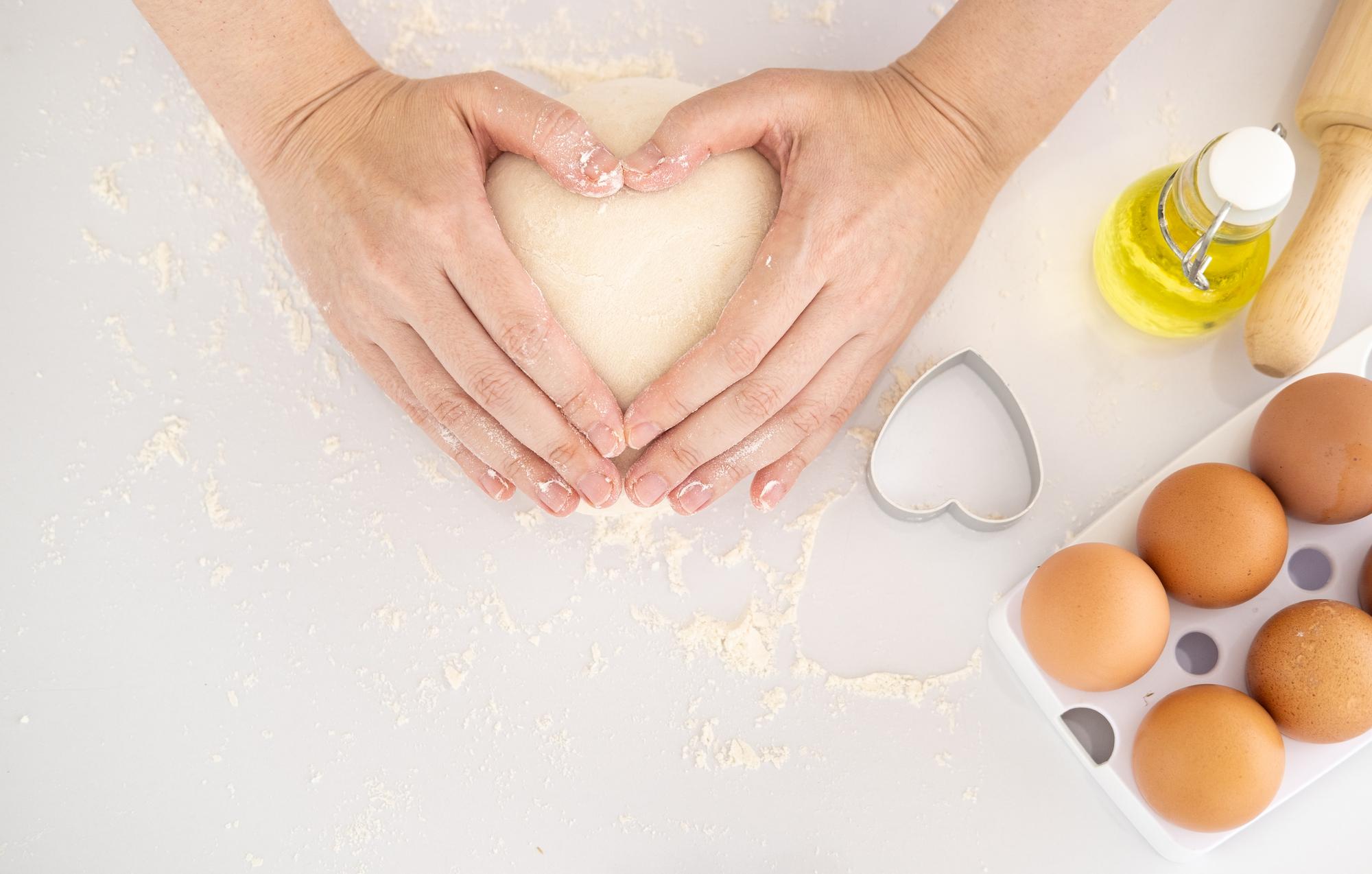 hands folding dough over filling in bright kitchen